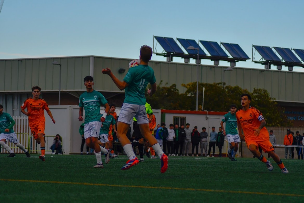 Two women sitting at a modern table talking with a city view behind them.